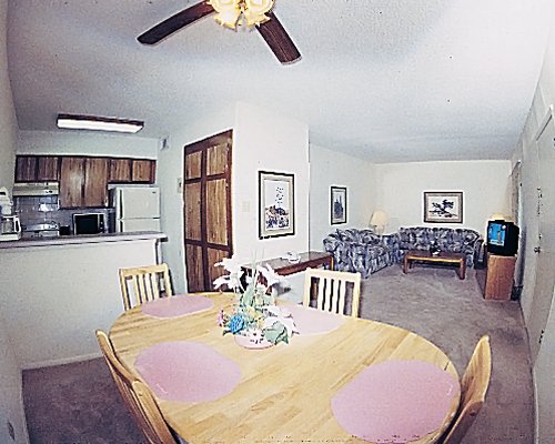 An open plan living dining and kitchen area with a television.