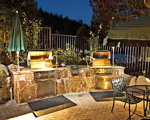 An outdoor area with barbecue grills and patio furniture.