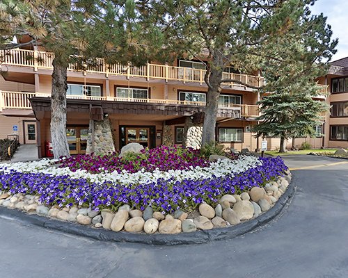 An exterior view of the multi story resort with assorted flowers.
