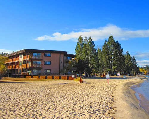 A beach view of multi story resort units surrounded by trees.