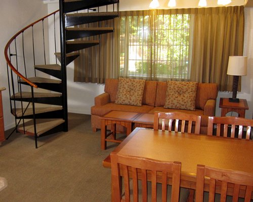 Furnished living room with dining area and stairway.