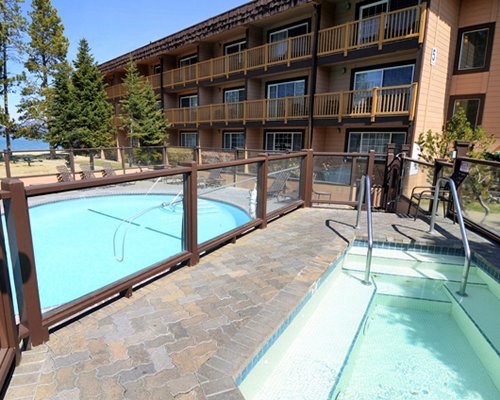 An outdoor swimming pool with hot tub alongside resort units.