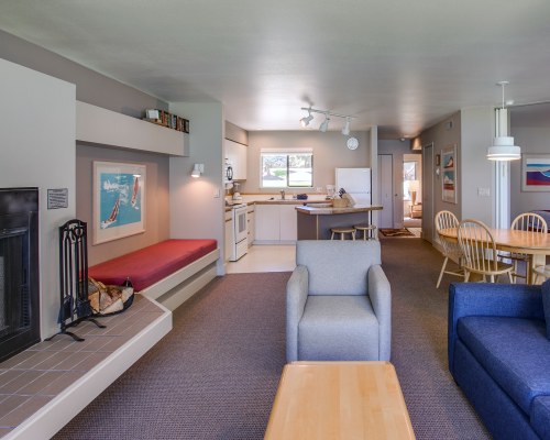 AN OPEN PLAN LIVING ROOM WITH A FIREPLACE DINING AND KITCHEN AREA.