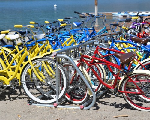 A SET OF BI CYCLES LINED UP ALONGSIDE MARINA.