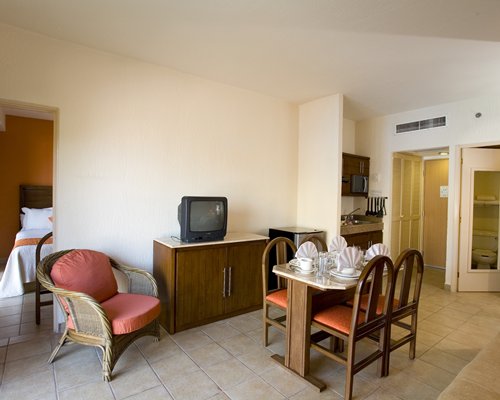 A couple at well furnished bedroom with two beds and a television.
