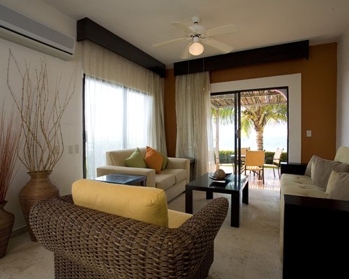 A well furnished bedroom with two twin beds an open plan kitchen and television.