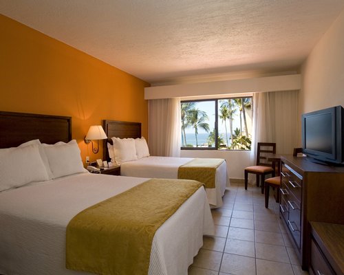 A well furnished bedroom with king bed balcony and ocean view.
