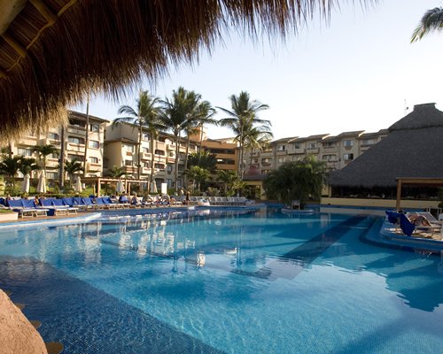 An outdoor swimming pool alongside the resort and a poolside bar.