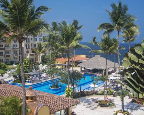 An outdoor swimming pool with chaise lounge chairs and poolside bar.