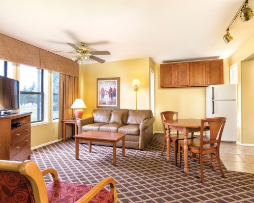 A WELL FURNISHED OPEN PLAN LIVING AND DINING AREA WITH A TELEVISION DOUBLE PULL OUT SOFA AND AN OUTSIDE VIEW.