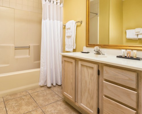 A BATHROOM WITH SHOWER BATHTUB AND CLOSED VANITY SINK.