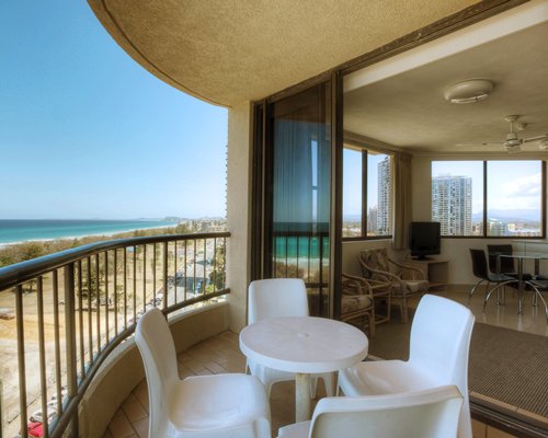 A balcony with patio furniture alongside the beach.