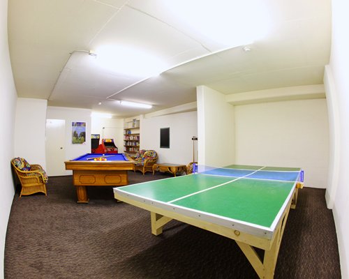 An indoor recreation room with pool table and ping pong.