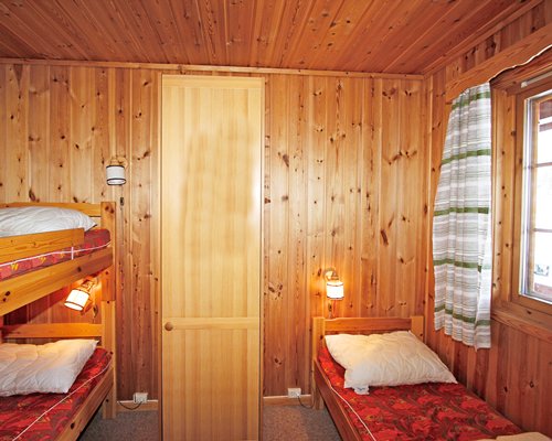 A well furnished bedroom with bunk beds and outside view.
