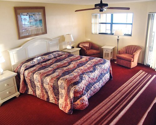 A well furnished bedroom with a king bed and an outside view.