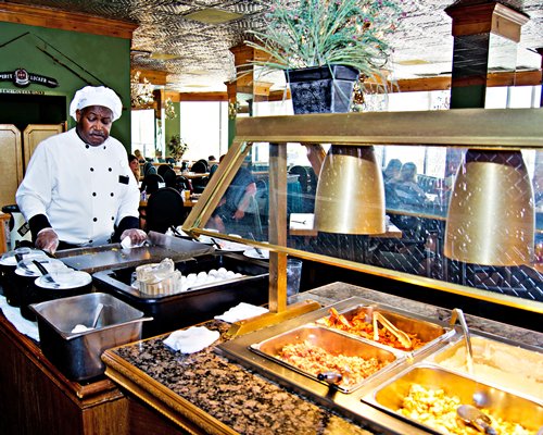 A chef at an indoor restaurant with buffet.
