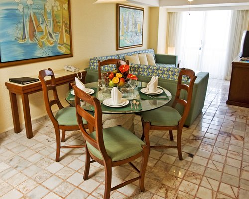 An Open plan living with a television and glass top dining area.
