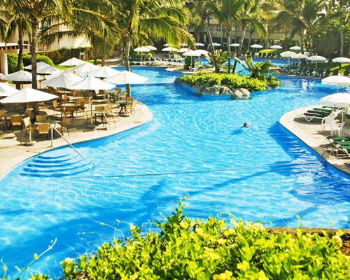 An indoor swimming pool with chaise lounge chairs alongside resort condos.