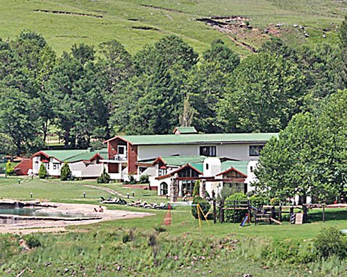 Exterior view of Bushman'S Nek Berg & Trout Resort with kids playscape and waterfront surrounded by wooded area.