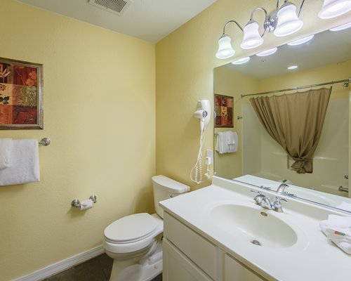 A bathroom with single sink vanity and view of shower bathtub.