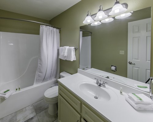 A bathroom with single sink vanity and bathtub.