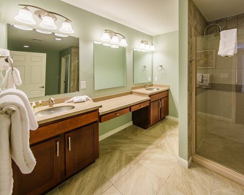 A large bathroom with double sink vanity and shower stall.