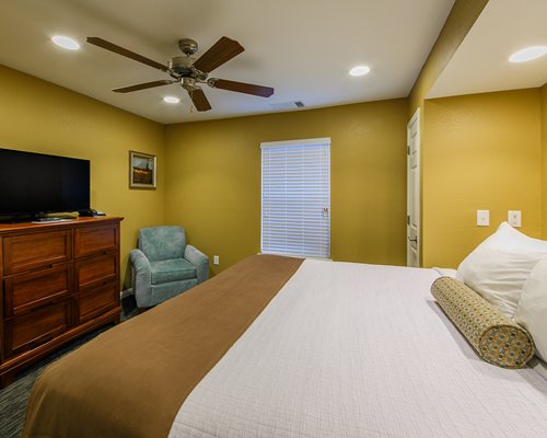 A bedroom with a large bed and television.