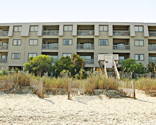 Scenic exterior view of Peppertree Sandpebble Beach Club with multiple unit balconies and stairway.