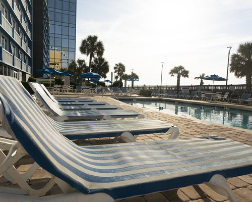 An outdoor swimming pool with chase lounge chairs.