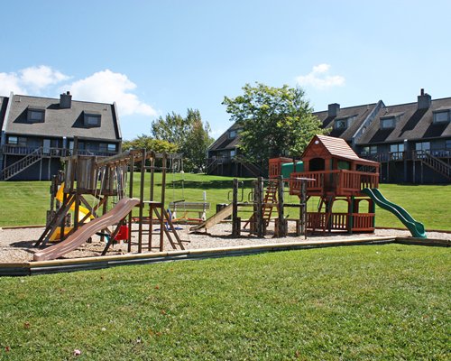 An outdoor playscape for kids alongside multiple resort units.
