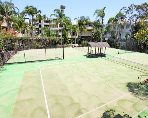 An outdoor tennis courts surrounded by trees.