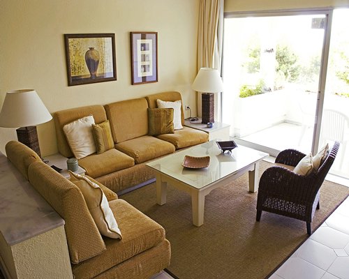 A well furnished living room with outdoor patio and patio chairs.