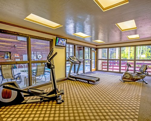 A well equipped fitness center with outside view.
