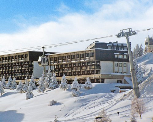 A cable car alongside the resort units covered by snow.