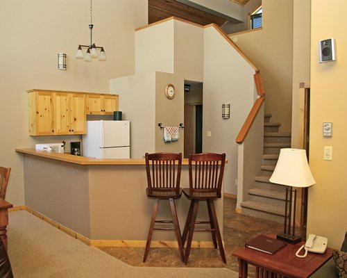 A well equipped kitchen with a breakfast bar and a stairway.