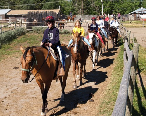 View of people riding horses alongside the resort units.
