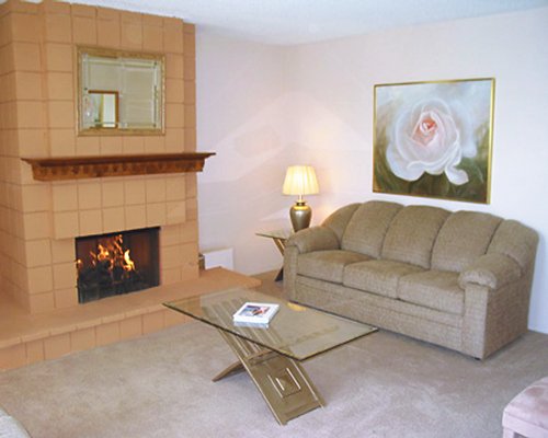 A well furnished living room with the fire in the fireplace.