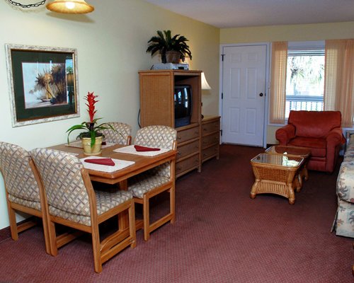 A well furnished living room with the television and dining area.