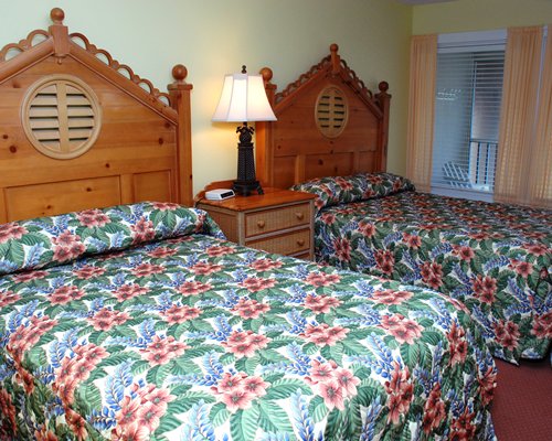 A well furnished bedroom with two queen beds and balcony.