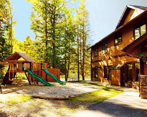 Scenic exterior view of the resort with a playscape alongside the trees.