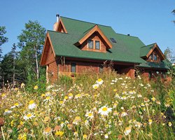 An exterior view of a resort unit surrounded by trees and flowers.
