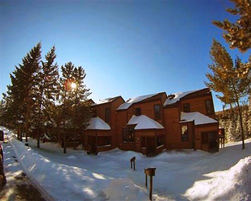 An exterior view of multi story resort units covered in snow.