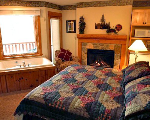 A well furnished bedroom with a fireplace sink and an outside view.