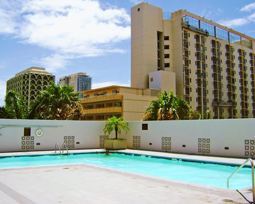An outdoor swimming pool alongside multi story resort units.