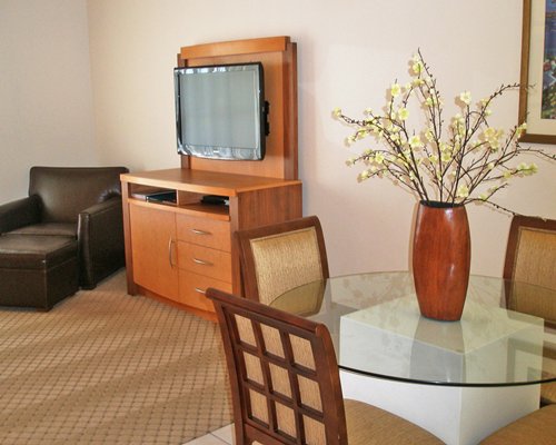 A well furnished living room with television and dining area.