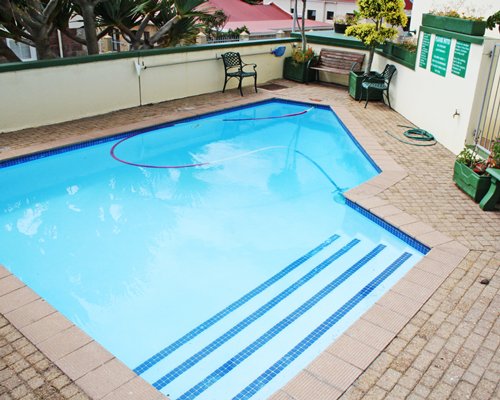 An outdoor swimming pool with patio furniture.