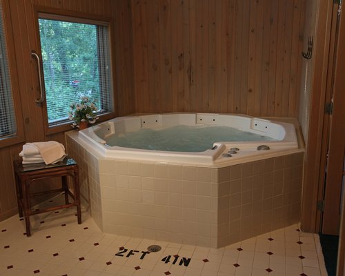 A view of an indoor hot tub with an outside view.