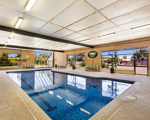 Indoor swimming pool with outside view.