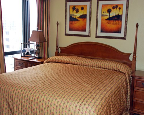A well furnished bedroom with queen bed and beach view.
