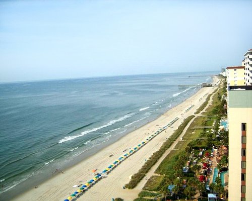 An aerial view of beach and ocean with sunshades.